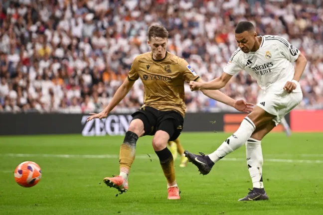 MADRID, SPAIN - MAY 24: Kylian Mbappe of Real Madrid scores his team's second goal whilst under pressure from Jon Pacheco of Real Sociedad during the LaLiga match between Real Madrid CF and Real Sociedad at Estadio Santiago Bernabeu on May 24, 2025 in Madrid, Spain. (Photo by Denis Doyle/Getty Images)