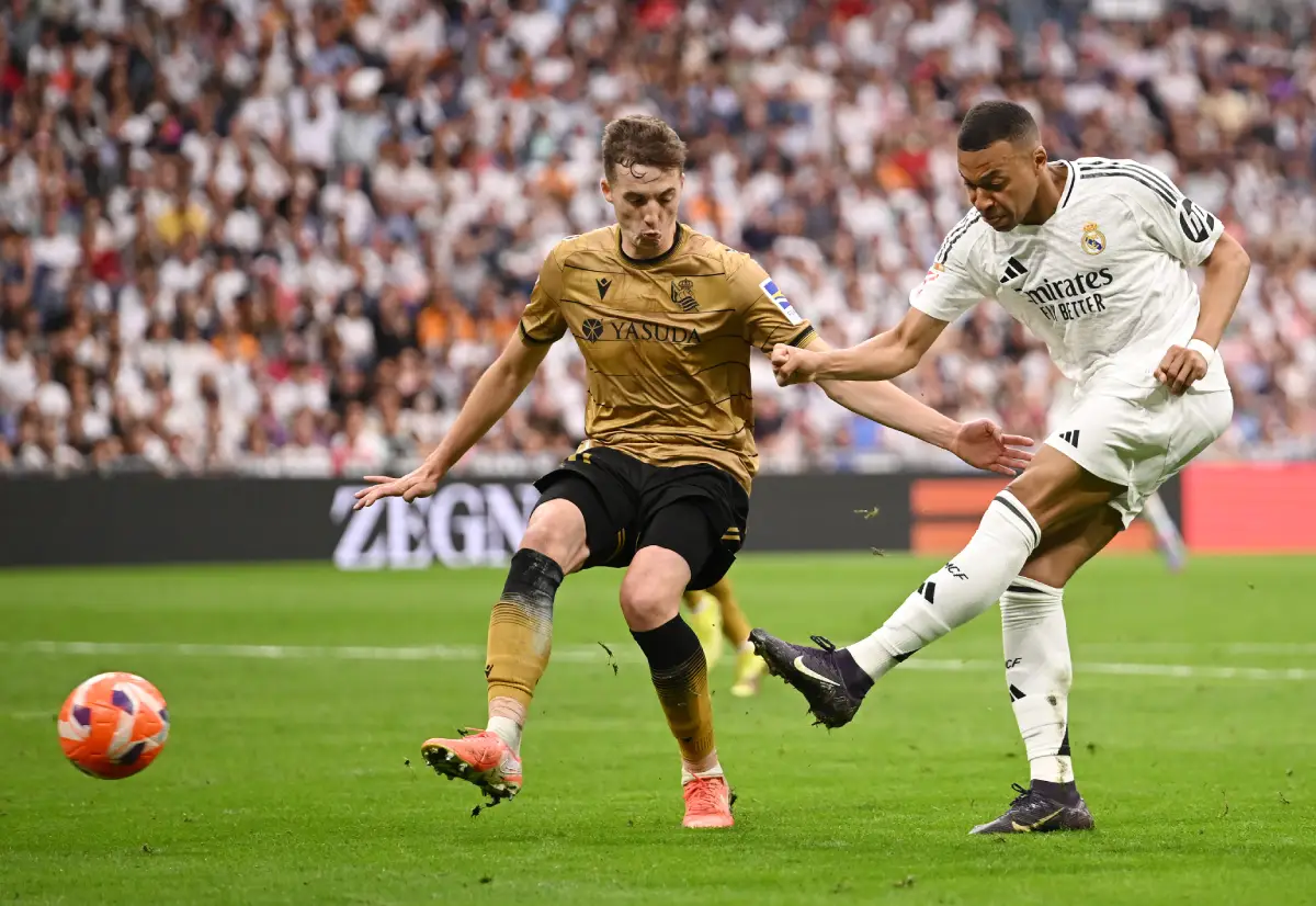 MADRID, SPAIN - MAY 24: Kylian Mbappe of Real Madrid scores his team's second goal whilst under pressure from Jon Pacheco of Real Sociedad during the LaLiga match between Real Madrid CF and Real Sociedad at Estadio Santiago Bernabeu on May 24, 2025 in Madrid, Spain. (Photo by Denis Doyle/Getty Images)