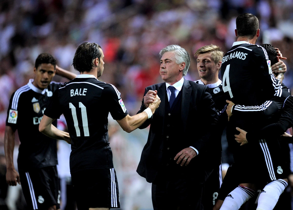 SEVILLE, SPAIN - MAY 02: Head coach Carlo Ancelotti of Real Madrid celebrates with Gareth Bale after Cristiano Ronaldo scored his team's 3rd goal during the La Liga match between Sevilla FC and Real Madrid CF at Estadio Ramon Sanchez Pizjuan on May 2, 2015 in Seville, Spain. (Photo by Denis Doyle/Getty Images)