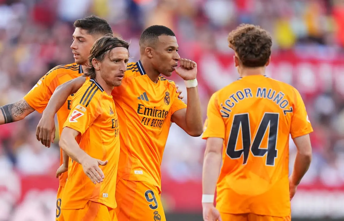 SEVILLE, SPAIN - MAY 18: Kylian Mbappe of Real Madrid celebrates scoring his team's first goal with teammates Luka Modric and Victor Munoz during the LaLiga match between Sevilla FC and Real Madrid CF at Estadio Ramon Sanchez Pizjuan on May 18, 2025 in Seville, Spain. (Photo by Angel Martinez/Getty Images)