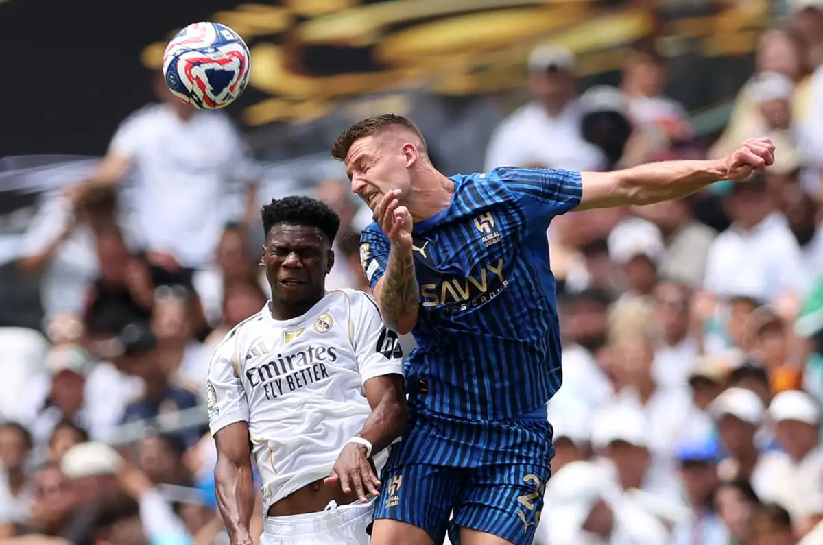 MIAMI GARDENS, FLORIDA - JUNE 18: Sergej Milinkovic-Savic #22 of Al Hilal heads the ball against Aurelien Tchouameni #14 of Real Madrid C.F. during the FIFA Club World Cup 2025 group H match between Real Madrid CF and Al Hilal at Hard Rock Stadium on June 18, 2025 in Miami Gardens, Florida. (Photo by Megan Briggs/Getty Images)