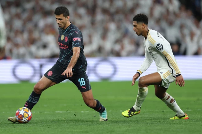 MADRID, SPAIN - APRIL 09: Rodri of Manchester City under pressure from Jude Bellingham of Real Madrid during the UEFA Champions League quarter-final first leg match between Real Madrid CF and Manchester City at Estadio Santiago Bernabeu on April 09, 2024 in Madrid, Spain.