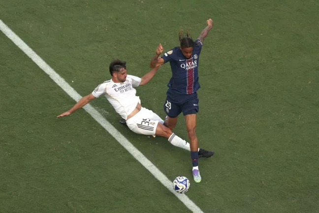 EAST RUTHERFORD, NEW JERSEY - JULY 09: Raul Asencio #35 of Real Madrid C.F. battles for possession with Bradley Barcola #29 of Paris Saint-Germain during the FIFA Club World Cup 2025 semi-final match between Paris Saint-Germain and Real Madrid CF at MetLife Stadium on July 09, 2025 in East Rutherford, New Jersey. (Photo by Al Bello/Getty Images)