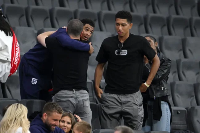FRANKFURT AM MAIN, GERMANY - JUNE 20: Jude Bellingham of England embraces Father Mark Bellingham as Brother Jobe Bellingham and Mother Denise Bellingham look on after the UEFA EURO 2024 group stage match between Denmark and England at Frankfurt Arena on June 20, 2024 in Frankfurt am Main, Germany. (Photo by Stu Forster/Getty Images)