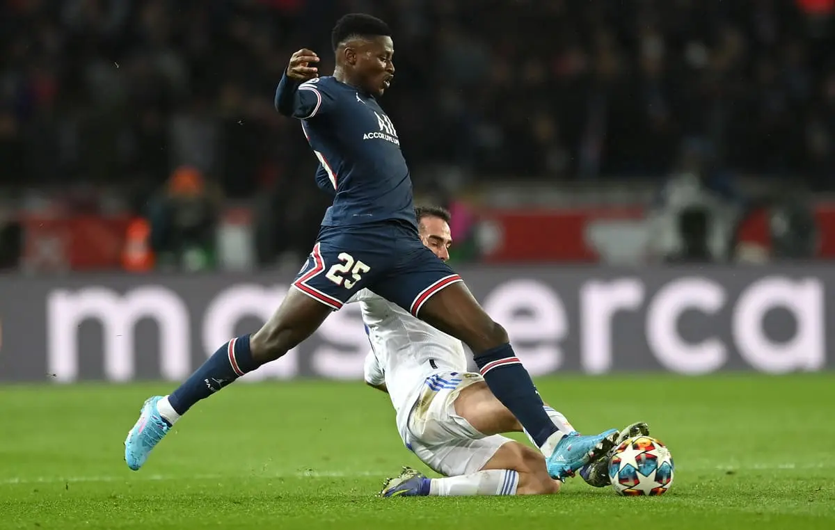 PARIS, FRANCE - FEBRUARY 15: Nuno Mendes of Paris Saint-Germain is challenged by Daniel Carvajal of Real Madrid during the UEFA Champions League Round Of Sixteen Leg One match between Paris Saint-Germain and Real Madrid at Parc des Princes on February 15, 2022 in Paris, France. (Photo by Shaun Botterill/Getty Images)