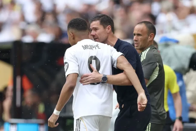 MIAMI GARDENS, FLORIDA - JULY 01: Kylian Mbappe #9 of Real Madrid C.F. speaks with Xabi Alonso, Head Coach of Real Madrid C.F., as he enters the pitch during the FIFA Club World Cup 2025 round of 16 match between Real Madrid CF and Juventus FC at Hard Rock Stadium on July 01, 2025 in Miami Gardens, Florida. (Photo by Megan Briggs/Getty Images)
