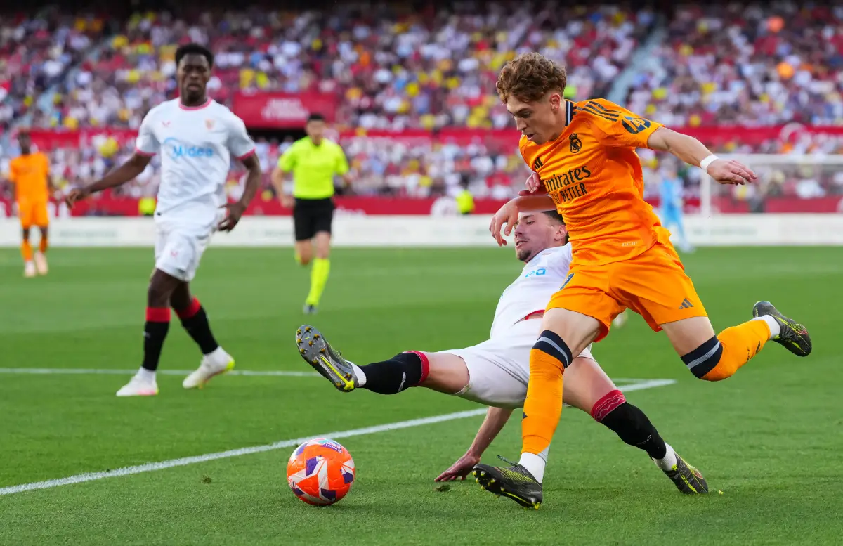 SEVILLE, SPAIN - MAY 18: Victor Munoz of Real Madrid is challenged by Jose Angel Carmona of Sevilla FC during the LaLiga match between Sevilla FC and Real Madrid CF at Estadio Ramon Sanchez Pizjuan on May 18, 2025 in Seville, Spain. (Photo by Angel Martinez/Getty Images)