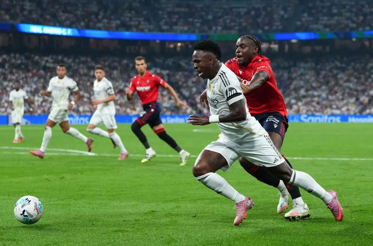 MADRID, SPAIN - AUGUST 19: Vinícius Jr. of Real Madrid is challenged by Flavien-Enzo Boyomo of Osasuna during the LaLiga EA Sports match between Real Madrid CF and CA Osasuna at Estadio Santiago Bernabeu on August 19, 2025 in Madrid, Spain. (Photo by Angel Martinez/Getty Images)