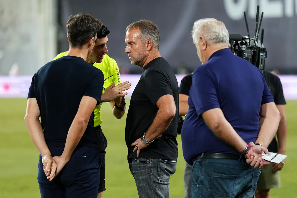 MADRID, SPAIN - AUGUST 31: Referee Mateo Busquets Ferrer tells Inigo Perez, Head Coach of Rayo Vallecano, and Hansi Flick, Head Coach of FC Barcelona, that he cant communicate with the of VAR room, so they wont use the VAR until they can reach the communication with the VAR room during the LaLiga EA Sports match between Rayo Vallecano de Madrid and FC Barcelona at Estadio de Vallecas on August 31, 2025 in Madrid, Spain because of technical problems according to Mediapro. (Photo by Angel Martinez/Getty Images)