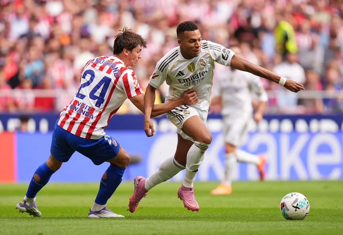 MADRID, SPAIN - SEPTEMBER 27: Kylian Mbappe of Real Madrid is challenged by Robin Le Normand of Atletico de Madrid during the LaLiga EA Sports match between Atletico de Madrid and Real Madrid CF at Riyadh Air Metropolitano on September 27, 2025 in Madrid, Spain. (Photo by Angel Martinez/Getty Images).