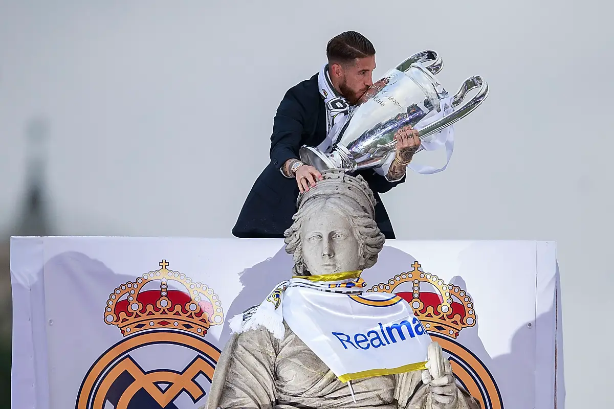MADRID, SPAIN - MAY 29: Captain Sergio Ramos of Real Madrid kisses the trophy as he touches Cibeles statue head as he celebrate with his team and fans at Cibeles square after winning the Uefa Champions League Final match against Club Atletico de Madrid on May 29, 2016 in Madrid, Spain. (Photo by Gonzalo Arroyo Moreno/Getty Images)