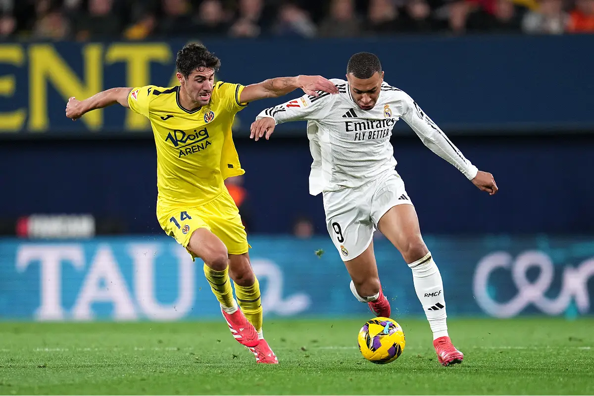 VILLARREAL, SPAIN - MARCH 15: Kylian Mbappe of Real Madrid is challenged by Santi Comesana of Villarreal CF during the LaLiga match between Villarreal CF and Real Madrid CF at Estadio de la Ceramica on March 15, 2025 in Villarreal, Spain. (Photo by Aitor Alcalde/Getty Images)