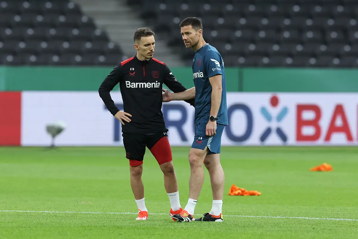 BERLIN, GERMANY - MAY 24: Xabi Alonso, Head Coach of Bayer 04 Leverkusen, speaks with Alejandro Grimaldo of Bayer 04 Leverkusen during a training session ahead of their DFB Cup 2023/24 final match against 1. FC Kaiserslautern at Olympiastadion on May 24, 2024 in Berlin, Germany. (Photo by Alexander Hassenstein/Getty Images)