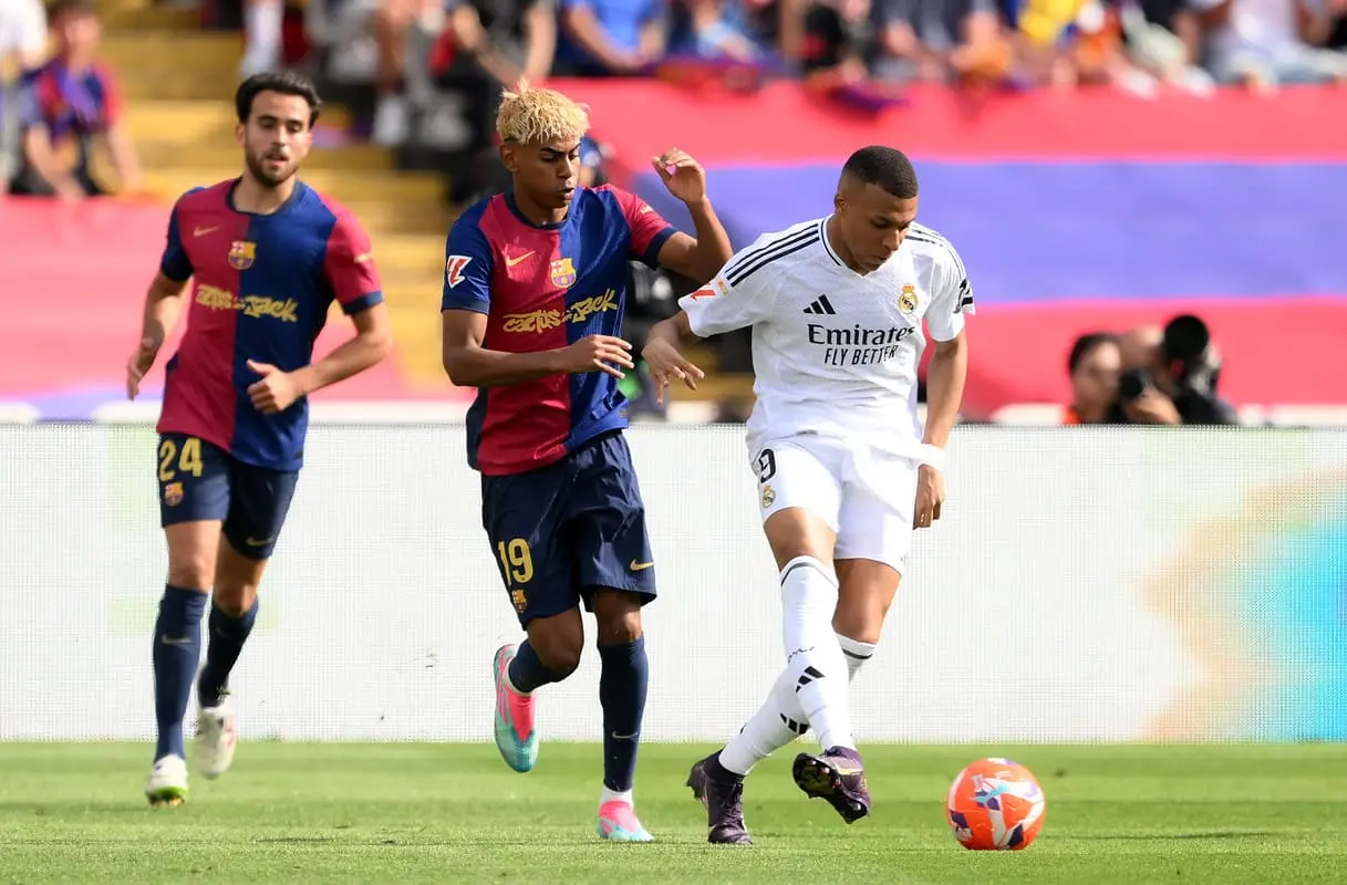 BARCELONA, SPAIN - MAY 11: Kylian Mbappe of Real Madrid passes the ball under pressure from Lamine Yamal of FC Barcelona during the LaLiga match between FC Barcelona and Real Madrid CF at Estadi Olimpic Lluis Companys on May 11, 2025 in Barcelona, Spain. (Photo by David Ramos/Getty Images)