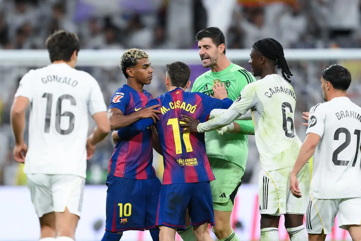 MADRID, SPAIN - OCTOBER 26: Lamine Yamal of FC Barcelona is held back by Marc Casado of FC Barcelona as players of Real Madrid Thibaut Courtois and Eduardo Camavinga of Real Madrid clash with him after the LaLiga EA Sports match between Real Madrid CF and FC Barcelona at Estadio Santiago Bernabeu on October 26, 2025 in Madrid, Spain. (Photo by David Ramos/Getty Images).