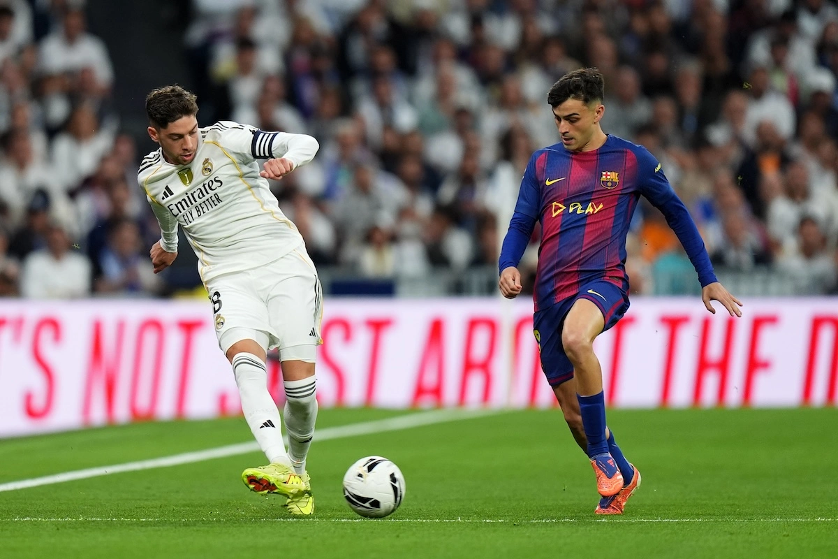 MADRID, SPAIN - OCTOBER 26: Federico Valverde of Real Madrid passes the ball whilst under pressure from Pedri of FC Barcelona during the LaLiga EA Sports match between Real Madrid CF and FC Barcelona at Estadio Santiago Bernabeu on October 26, 2025 in Madrid, Spain. (Photo by Angel Martinez/Getty Images)