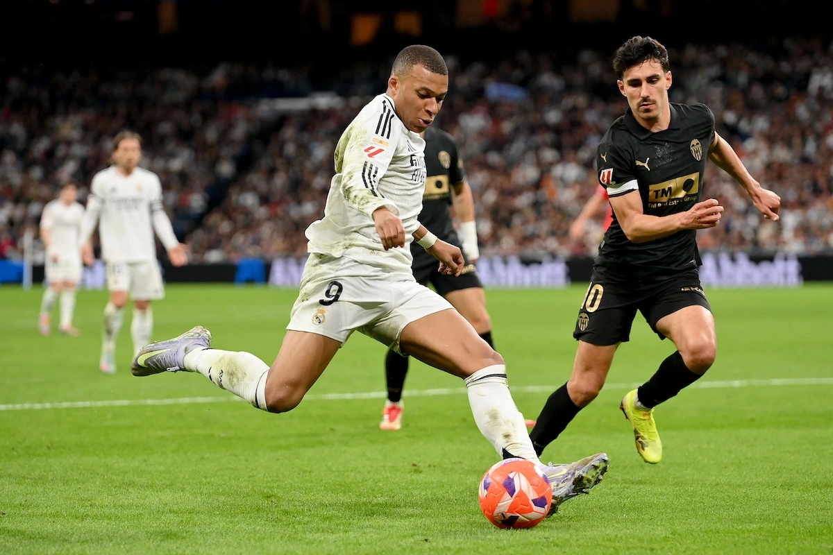MADRID, SPAIN - APRIL 05: Kylian Mbappe of Real Madrid runs with the ball whilst under pressure from Andre Almeida of Valencia CF during the LaLiga match between Real Madrid CF and Valencia CF at Estadio Santiago Bernabeu on April 05, 2025 in Madrid, Spain. (Photo by Denis Doyle/Getty Images)