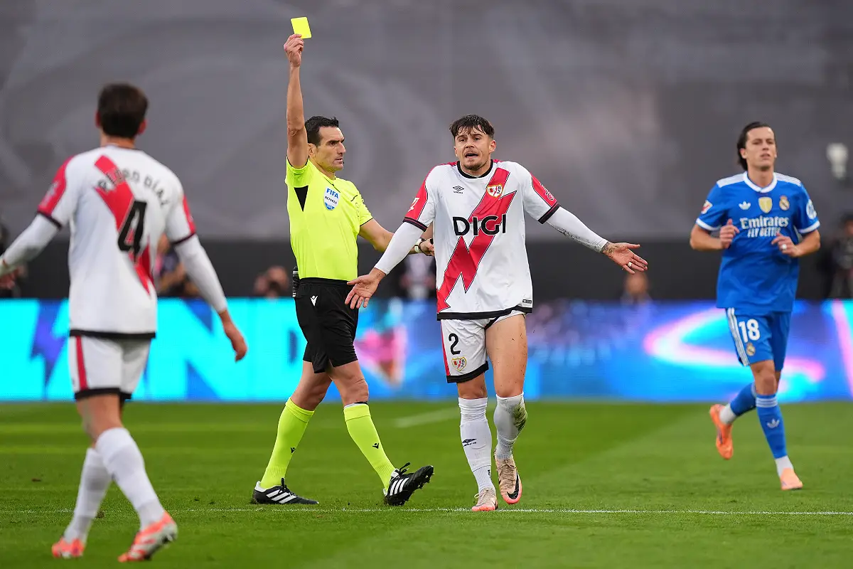 MADRID, SPAIN - NOVEMBER 09: Andrei Ratiu of Rayo Vallecano is shown a yellow card by referee Juan Martinez Munuera during the LaLiga EA Sports match between Rayo Vallecano de Madrid and Real Madrid CF at Estadio de Vallecas on November 09, 2025 in Madrid, Spain. (Photo by Angel Martinez/Getty Images)