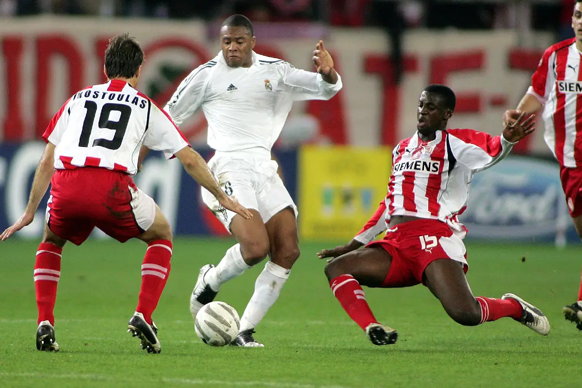 ATHENS, GREECE - DECEMBER 6: Athanasios Kostoulas #19 and Yaya Toure #15 of Olympiakos fight with Cesar Julio Baptista #8 of Real Madrid for control of the ball during the UEFA Champions League match between Olympiakos and Real Madrid on December 06, 2005 at Karaiskaki stadium in Athens, Greece. (Photo by Milos Bicanski/Getty Images)