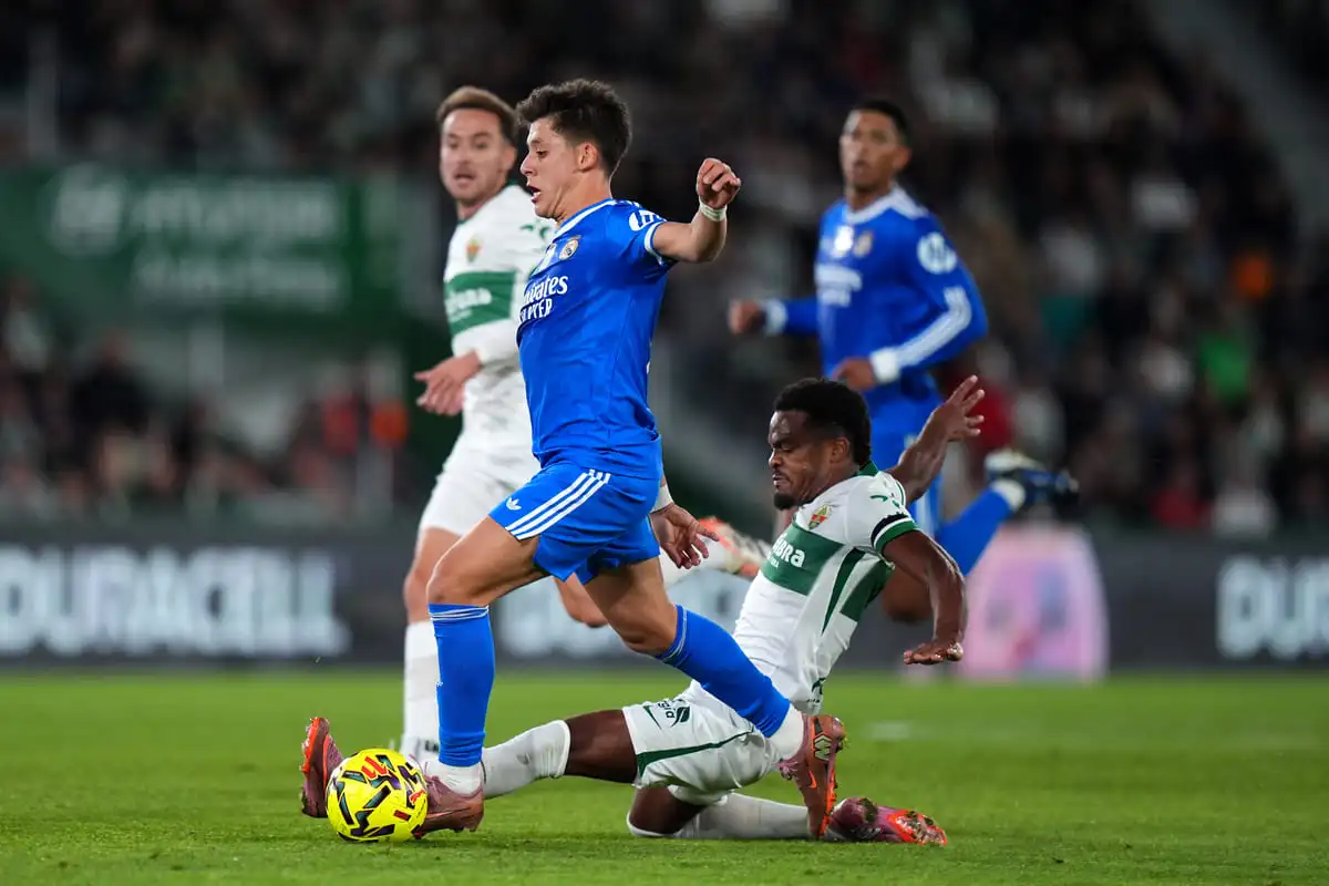 ELCHE, SPAIN - NOVEMBER 23: Arda Gueler of Real Madrid is tackled by Grady Diangana of Elche CF during the LaLiga EA Sports match between Elche CF and Real Madrid CF at Estadio Manuel Martinez Valero on November 23, 2025 in Elche, Spain. (Photo by Angel Martinez/Getty Images).