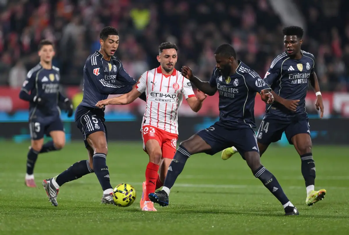 GIRONA, SPAIN - NOVEMBER 30: Ivan Martin of Girona is tackled by Antonio Ruediger of Real Madrid during the LaLiga EA Sports match between Girona FC and Real Madrid CF at Montilivi Stadium on November 30, 2025 in Girona, Spain. (Photo by David Ramos/Getty Images).