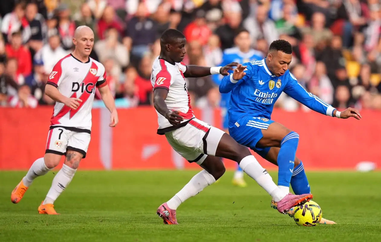 MADRID, SPAIN - NOVEMBER 09: Kylian Mbappe of Real Madrid is challenged by Nobel Mendy of Rayo Vallecano during the LaLiga EA Sports match between Rayo Vallecano de Madrid and Real Madrid CF at Estadio de Vallecas on November 09, 2025 in Madrid, Spain. (Photo by Angel Martinez/Getty Images)