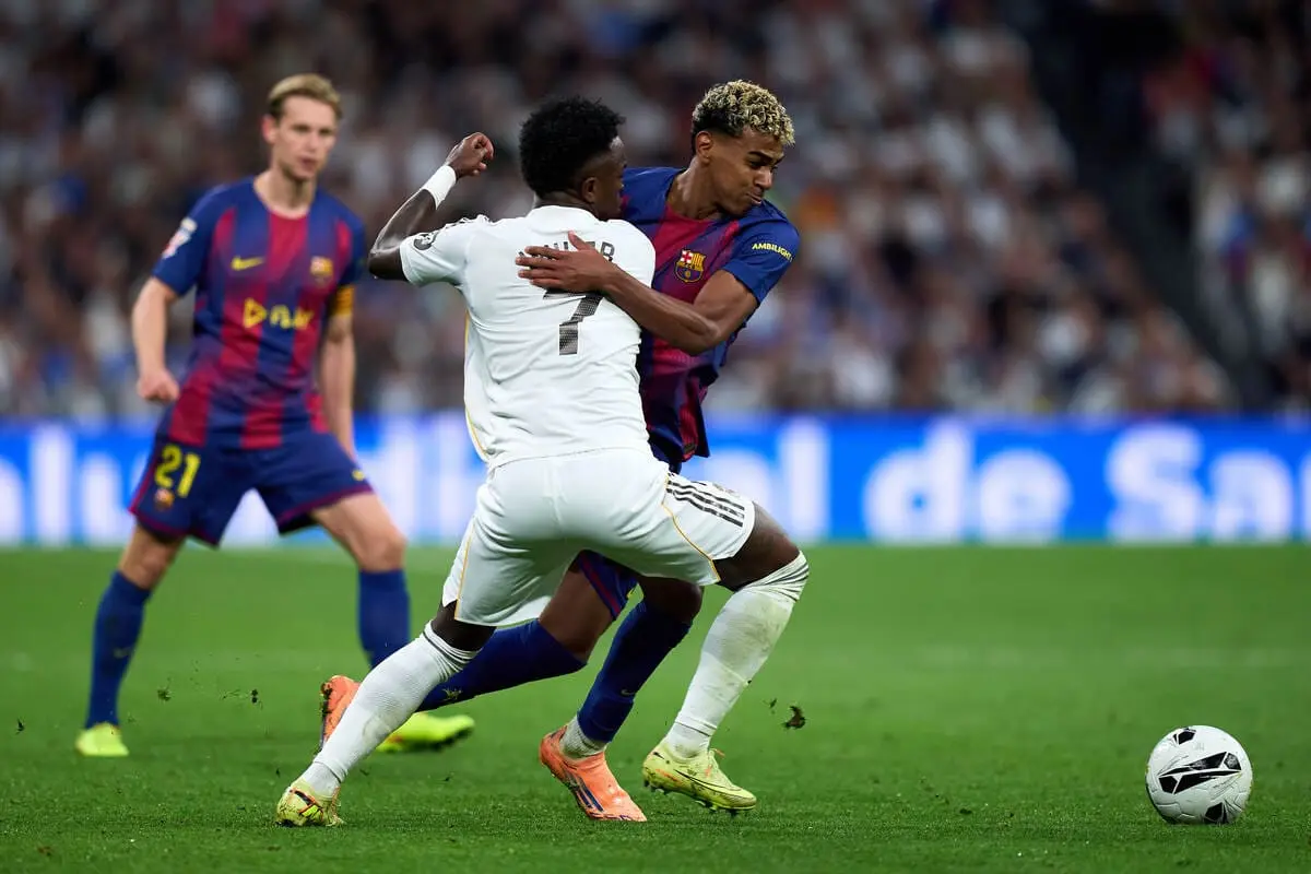MADRID, SPAIN - OCTOBER 26: Lamine Yamal of FC Barcelona battles for possession with Vinicius Junior of Real Madrid during the LaLiga EA Sports match between Real Madrid CF and FC Barcelona at Estadio Santiago Bernabeu on October 26, 2025 in Madrid, Spain. (Photo by Angel Martinez/Getty Images).