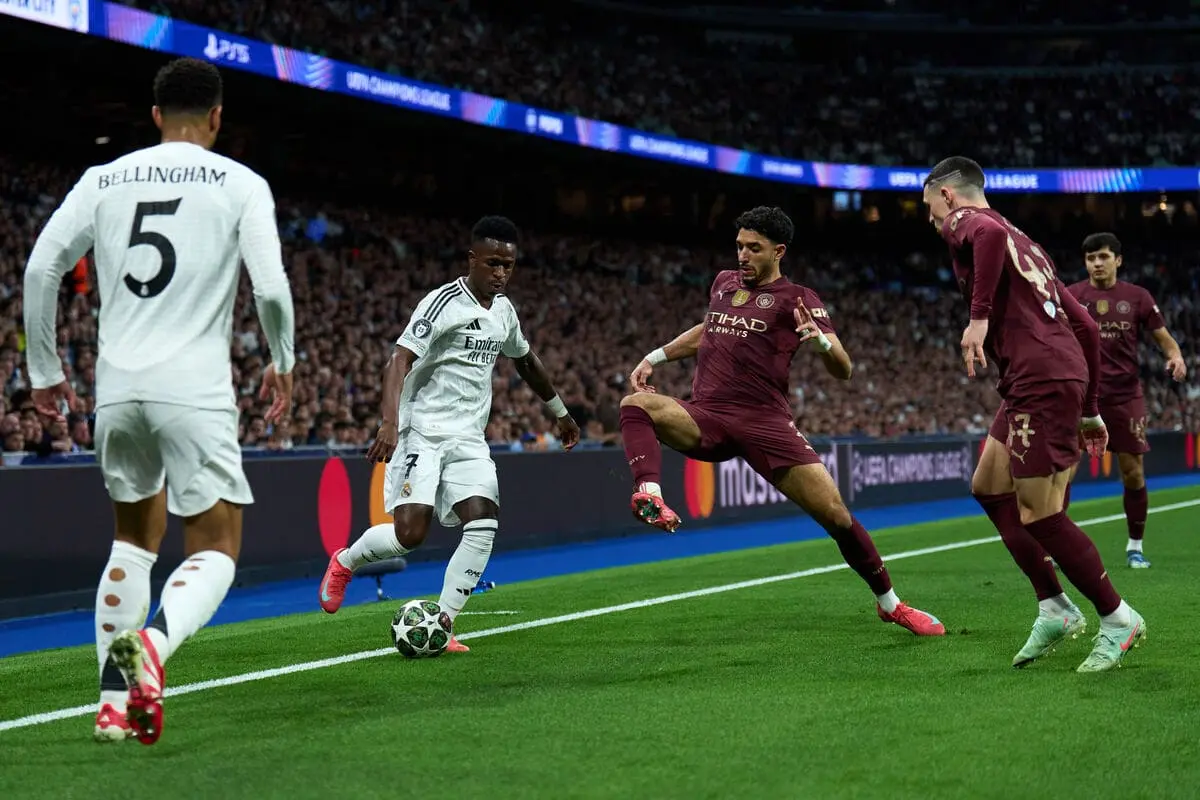 MADRID, SPAIN - FEBRUARY 19: Vinicius Junior of Real Madrid is challenged by Omar Marmoush of Manchester City during the UEFA Champions League 2024/25 League Knockout Play-off second leg match between Real Madrid C.F. and Manchester City at on February 19, 2025 in Madrid, Spain. (Photo by Angel Martinez/Getty Images).