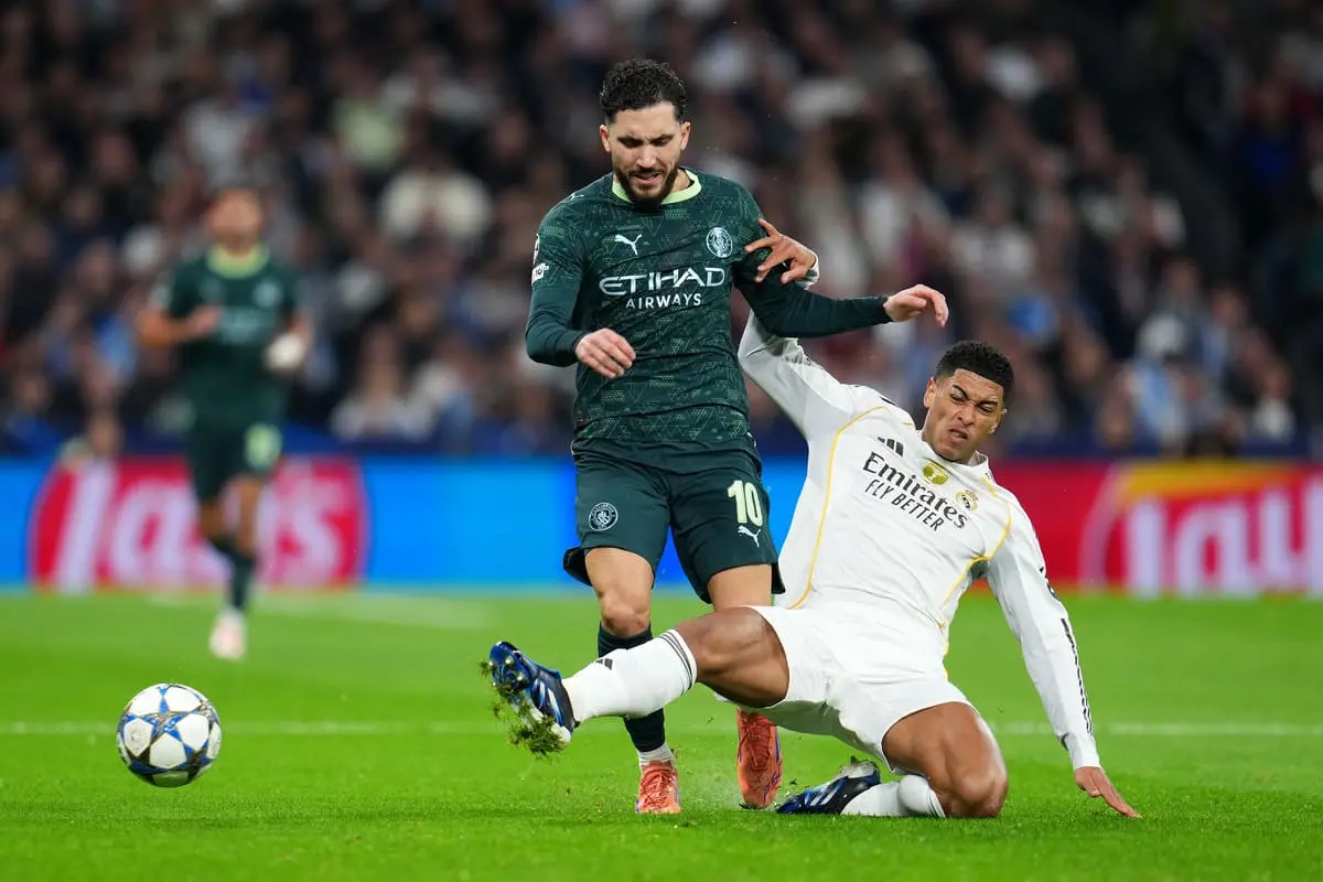 MADRID, SPAIN - DECEMBER 10: Rayan Cherki of Manchester City is challenged by Jude Bellingham of Real Madrid during the UEFA Champions League 2025/26 League Phase MD6 match between Real Madrid C.F. and Manchester City at Estadio Santiago Bernabeu on December 10, 2025 in Madrid, Spain. (Photo by Aitor Alcalde/Getty Images).