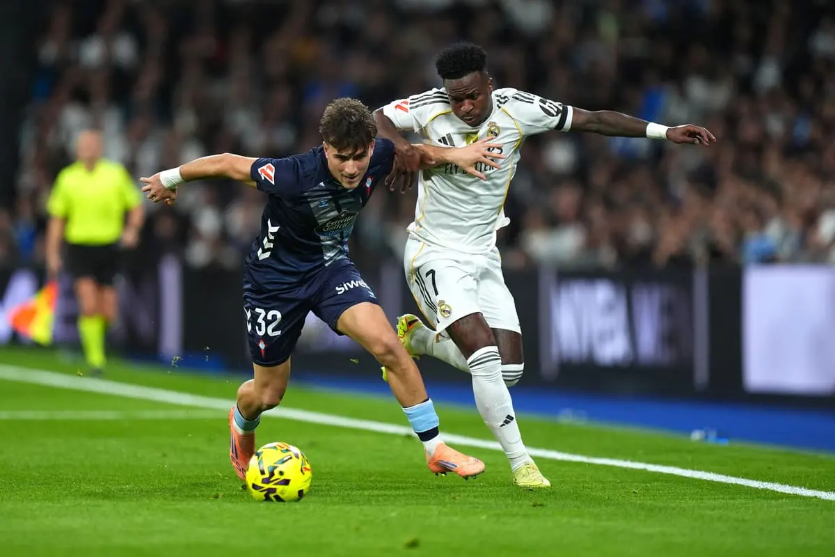 MADRID, SPAIN - DECEMBER 07: Vinicius Junior of Real Madrid battles for possession with Javi Rodriguez of Celta Vigo during the LaLiga EA Sports match between Real Madrid CF and RC Celta de Vigo at Estadio Santiago Bernabeu on December 07, 2025 in Madrid, Spain. (Photo by Angel Martinez/Getty Images).