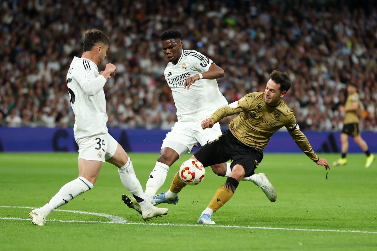 MADRID, SPAIN - APRIL 01: Martin Zubimendi of Real Sociedad battles for the ball with Raul Asencio and Aurelien Tchouameni of Real Madrid during the Copa del Rey semifinal match between Real Madrid and Real Sociedad at Estadio Santiago Bernabeu on April 01, 2025 in Madrid, Spain. (Photo by Florencia Tan Jun/Getty Images)