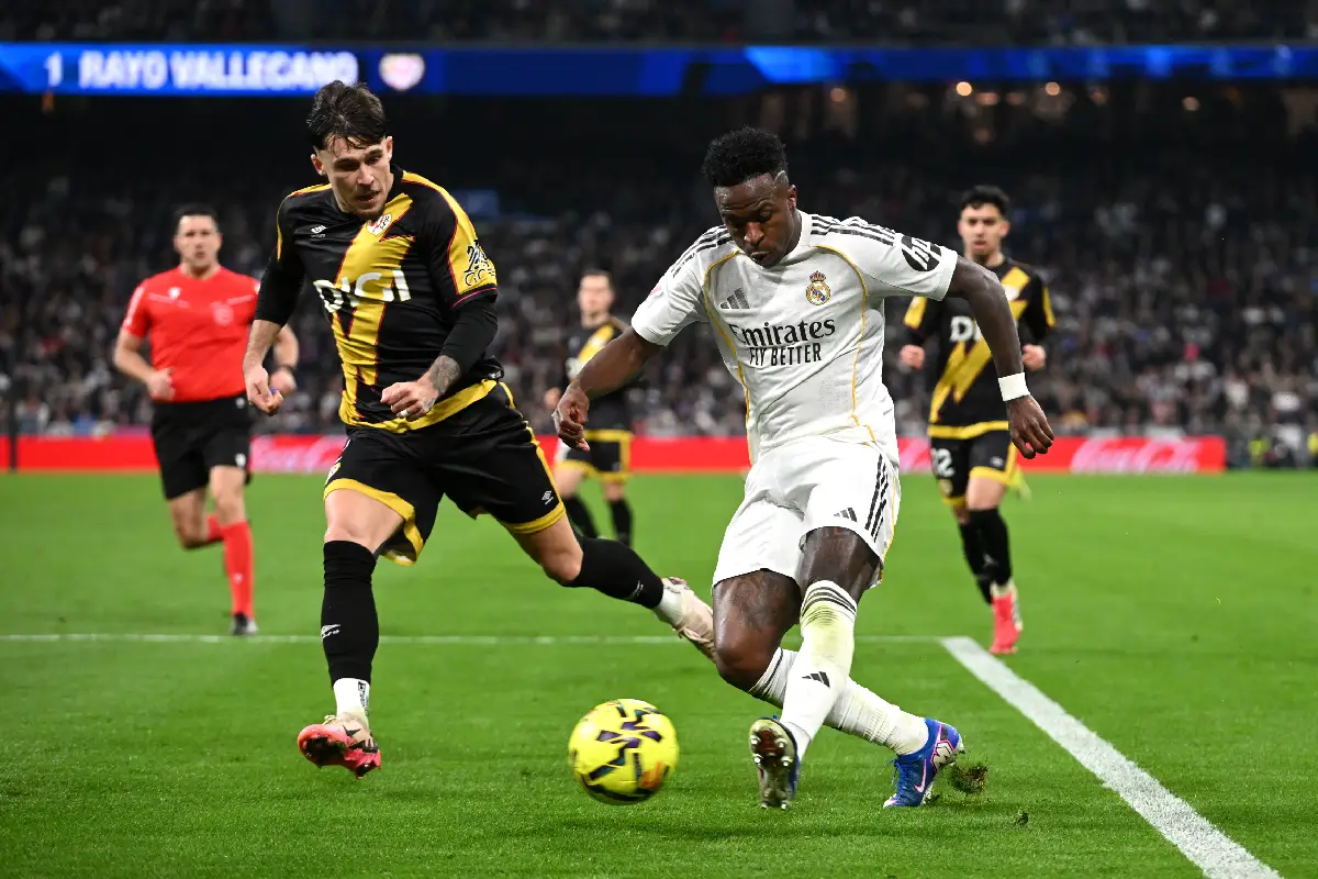 MADRID, SPAIN - FEBRUARY 01: Vinicius Junior of Real Madrid passes the ball whilst under pressure from Andrei Ratiu of Rayo Vallecano during the LaLiga EA Sports match between Real Madrid CF and Rayo Vallecano de Madrid at Estadio Santiago Bernabeu on February 01, 2026 in Madrid, Spain. (Photo by Denis Doyle/Getty Images)