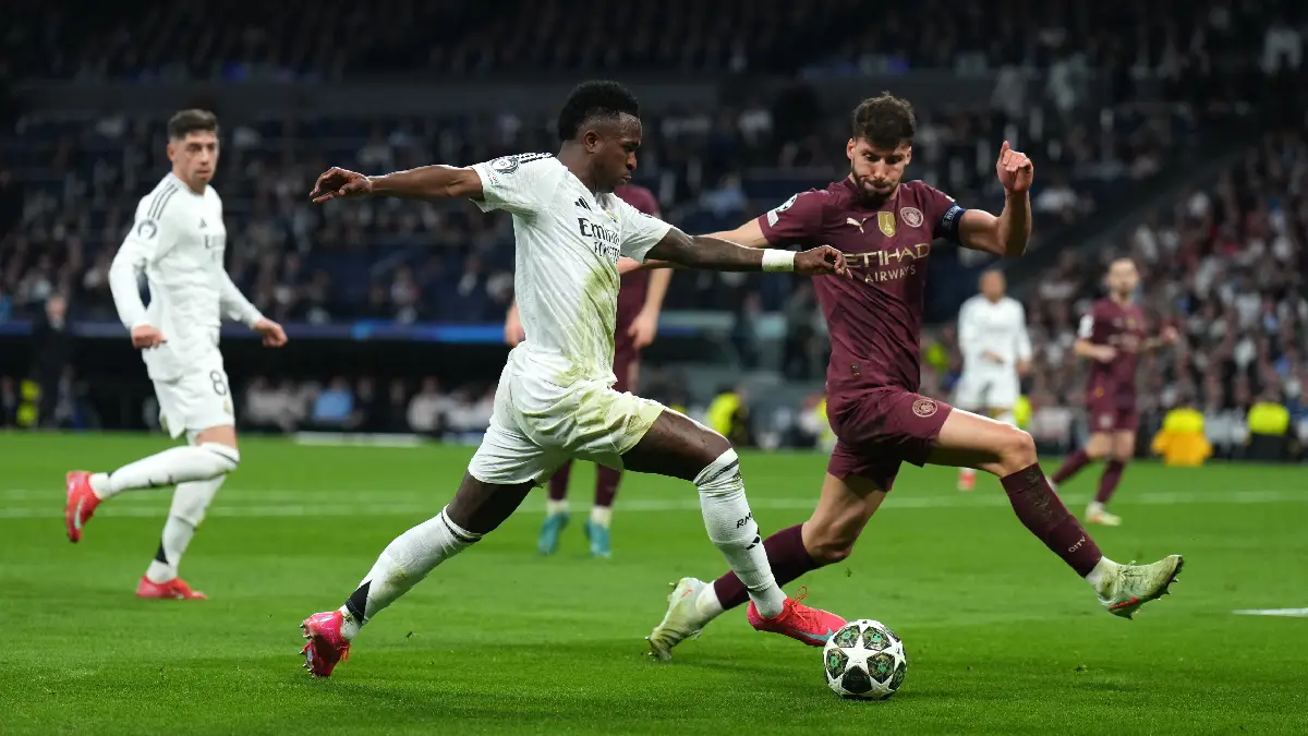 MADRID, SPAIN - FEBRUARY 19: Vinicius Junior of Real Madrid is challenged by Ruben Dias of Manchester City during the UEFA Champions League 2024/25 League Knockout Play-off second leg match between Real Madrid C.F. and Manchester City at Santiago Bernabeu Stadium on February 19, 2025 in Madrid, Spain. (Photo by Angel Martinez/Getty Images)