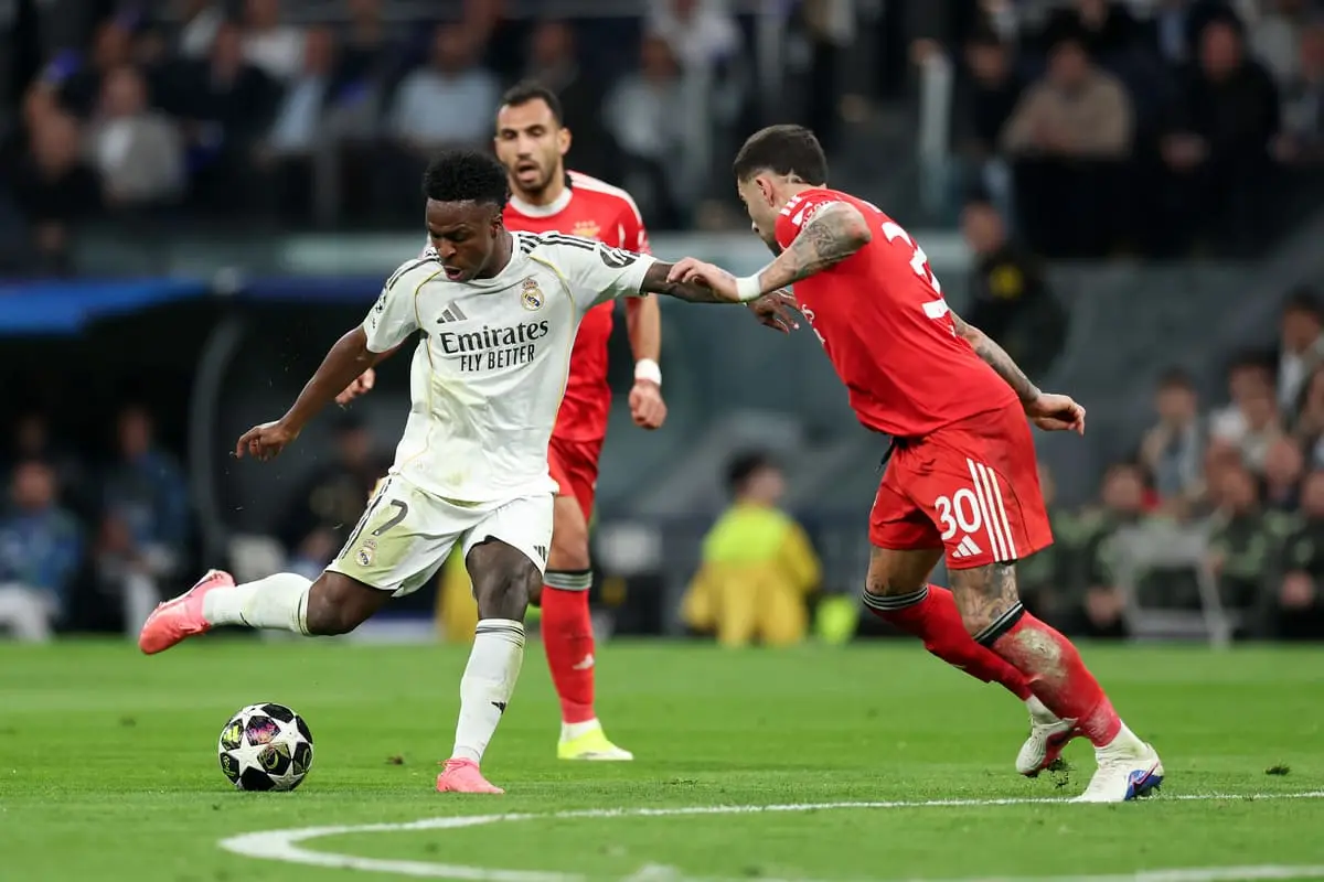 MADRID, SPAIN - FEBRUARY 25: Vinicius Junior of Real Madrid shoots past Nicolas Otamendi of Benfica during the UEFA Champions League 2025/26 League Knockout Play-off Second Leg match between Real Madrid C.F. and SL Benfica at Estadio Santiago Bernabeu on February 25, 2026 in Madrid, Spain. (Photo by Clive Brunskill/Getty Images).
