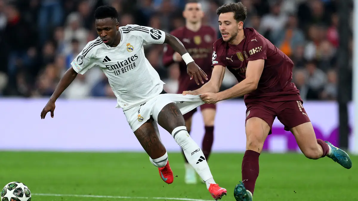 MADRID, SPAIN - FEBRUARY 19: Vinicius Junior of Real Madrid is challenged by Nico Gonzalez of Manchester City during the UEFA Champions League 2024/25 League Knockout Play-off second leg match between Real Madrid C.F. and Manchester City at Santiago Bernabeu Stadium on February 19, 2025 in Madrid, Spain. (Photo by David Ramos/Getty Images)