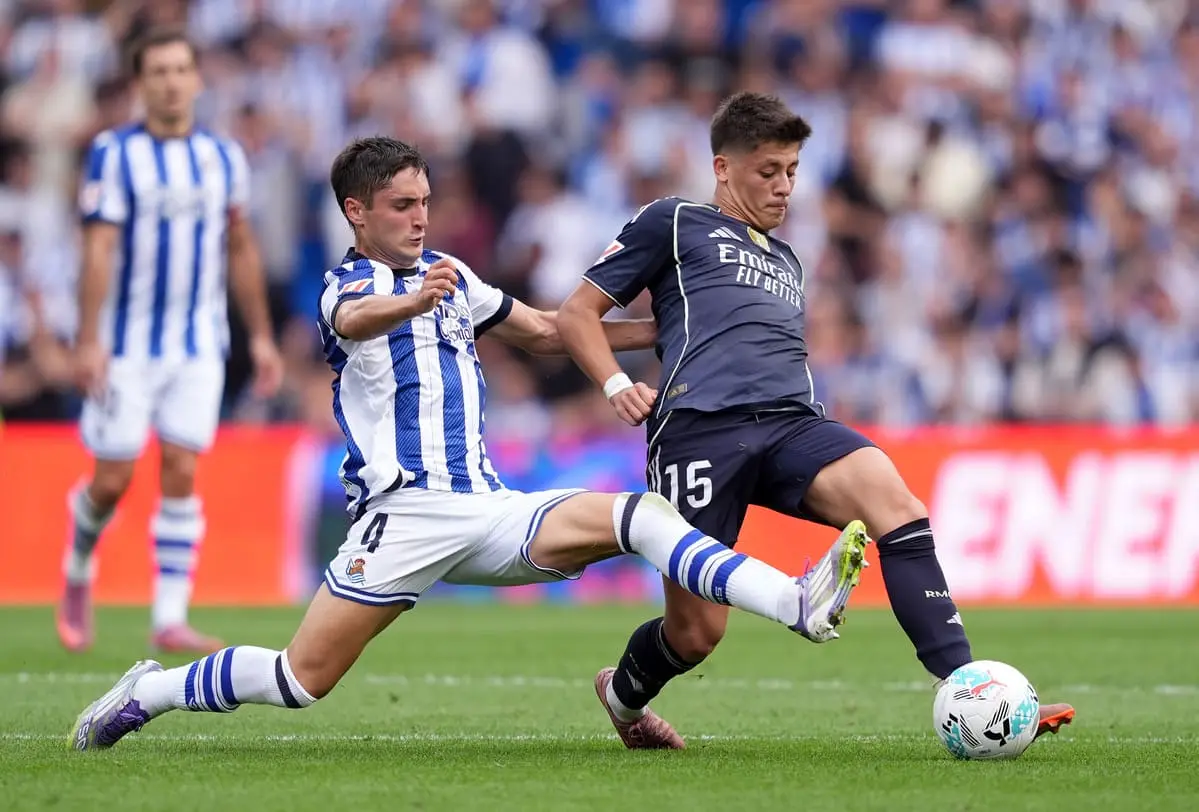 SAN SEBASTIAN, SPAIN - SEPTEMBER 13: Arda Gueler of Real Madrid is challenged by Jon Gorrotxategi of Real Sociedad during the LaLiga EA Sports match between Real Sociedad and Real Madrid CF at Reale Arena on September 13, 2025 in San Sebastian, Spain. (Photo by Juan Manuel Serrano Arce/Getty Images).