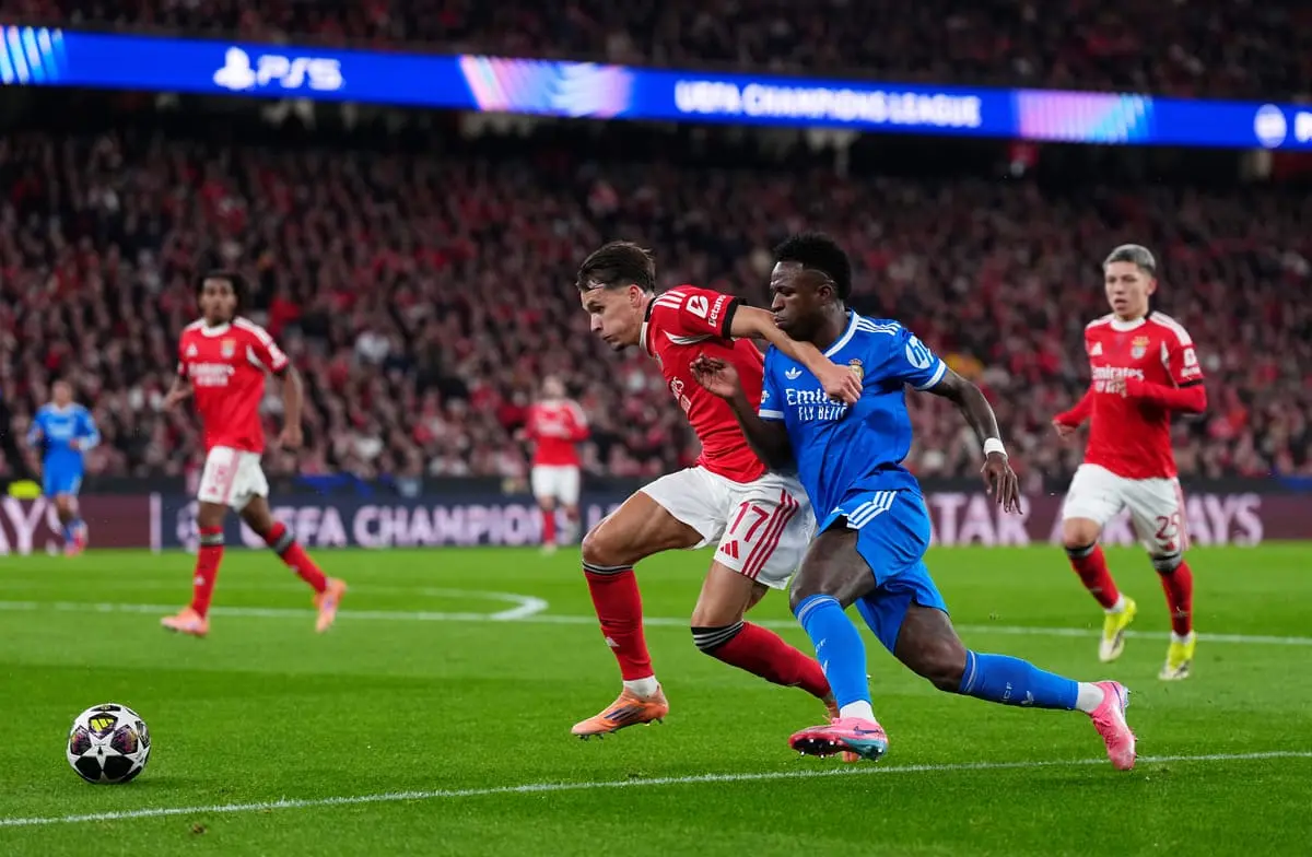 LISBON, PORTUGAL - FEBRUARY 17: Amar Dedic of Benfica battles for possession with Vinicius Junior of Real Madrid during the UEFA Champions League 2025/26 League Knockout Play-off First Leg match between SL Benfica and Real Madrid C.F. at Estadio do SL Benfica on February 17, 2026 in Lisbon, Portugal. (Photo by Angel Martinez/Getty Images).