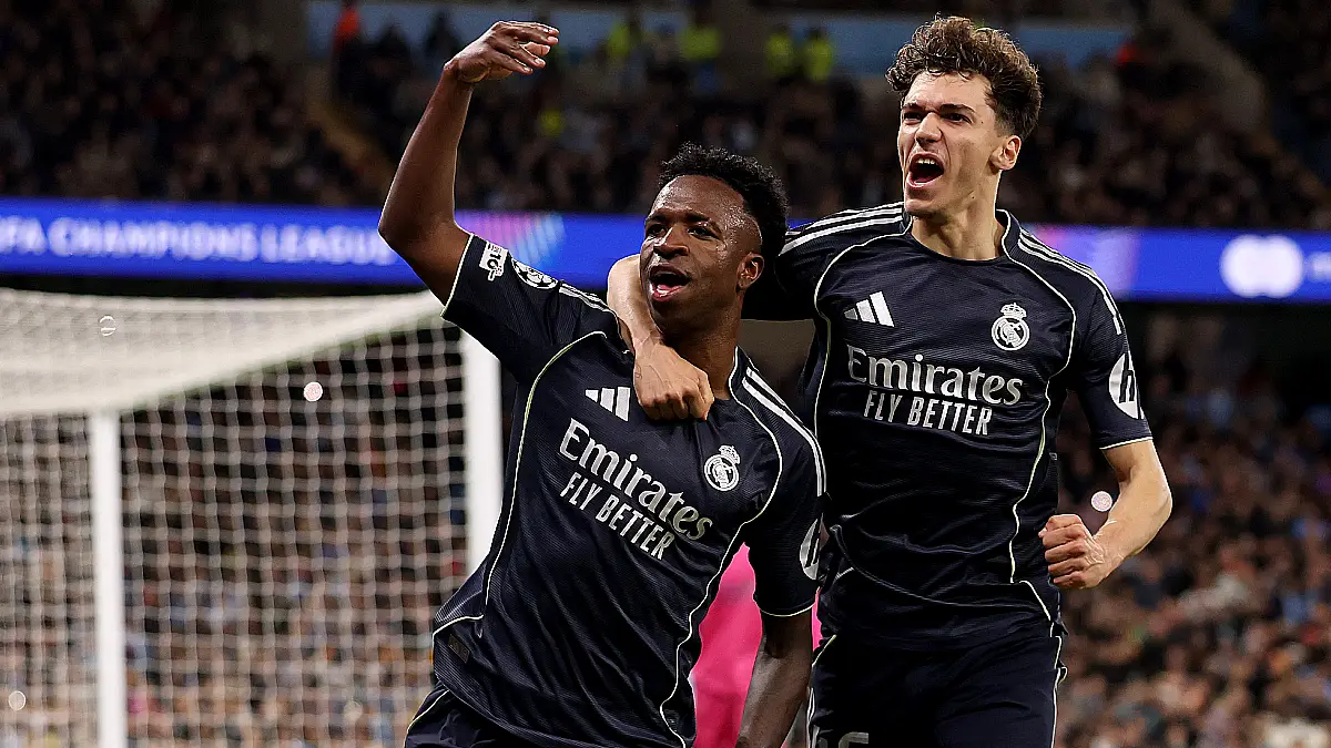 MANCHESTER, ENGLAND - MARCH 17: Vinicius Junior of Real Madrid celebrates scoring his team's first goal from the penalty spot with teammate Thiago Pitarch during the UEFA Champions League 2025/26 Round of 16 Second Leg match between Manchester City FC and Real Madrid CF at City of Manchester Stadium on March 17, 2026 in Manchester, England. (Photo by Carl Recine/Getty Images)