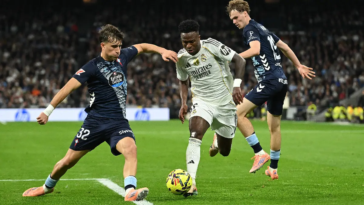 MADRID, SPAIN - DECEMBER 07: Vinicius Junior of Real Madridis tackled by Javi Rodriguez of Celta Vigo during the LaLiga EA Sports match between Real Madrid CF and RC Celta de Vigo at Estadio Santiago Bernabeu on December 07, 2025 in Madrid, Spain. (Photo by Denis Doyle/Getty Images)
