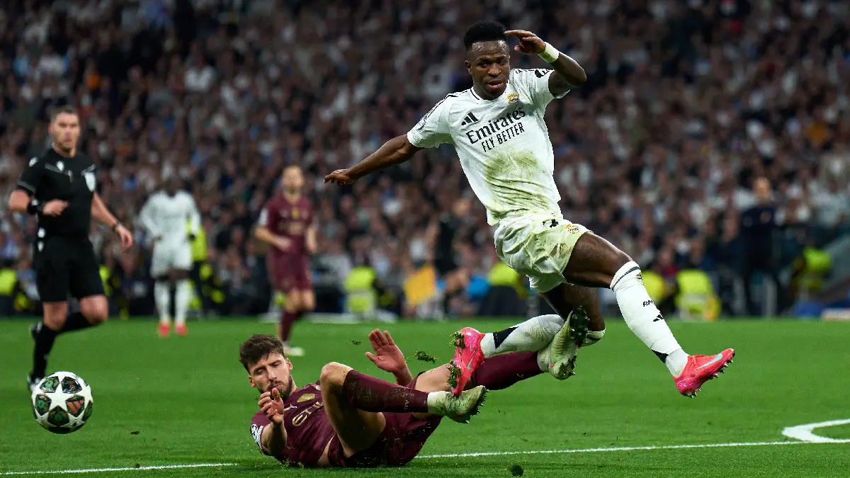 MADRID, SPAIN - FEBRUARY 19: Vinicius Junior of Real Madrid is challenged by Ruben Dias of Manchester City during the UEFA Champions League 2024/25 League Knockout Play-off second leg match between Real Madrid C.F. and Manchester City at on February 19, 2025 in Madrid, Spain. (Photo by Angel Martinez/Getty Images)