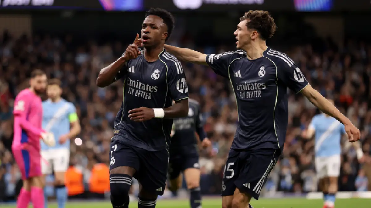 MANCHESTER, ENGLAND - MARCH 17: Vinicius Junior of Real Madrid celebrates scoring his team's first goal from the penalty spot with teammate Thiago Pitarch during the UEFA Champions League 2025/26 Round of 16 Second Leg match between Manchester City FC and Real Madrid CF at City of Manchester Stadium on March 17, 2026 in Manchester, England. (Photo by Carl Recine/Getty Images)