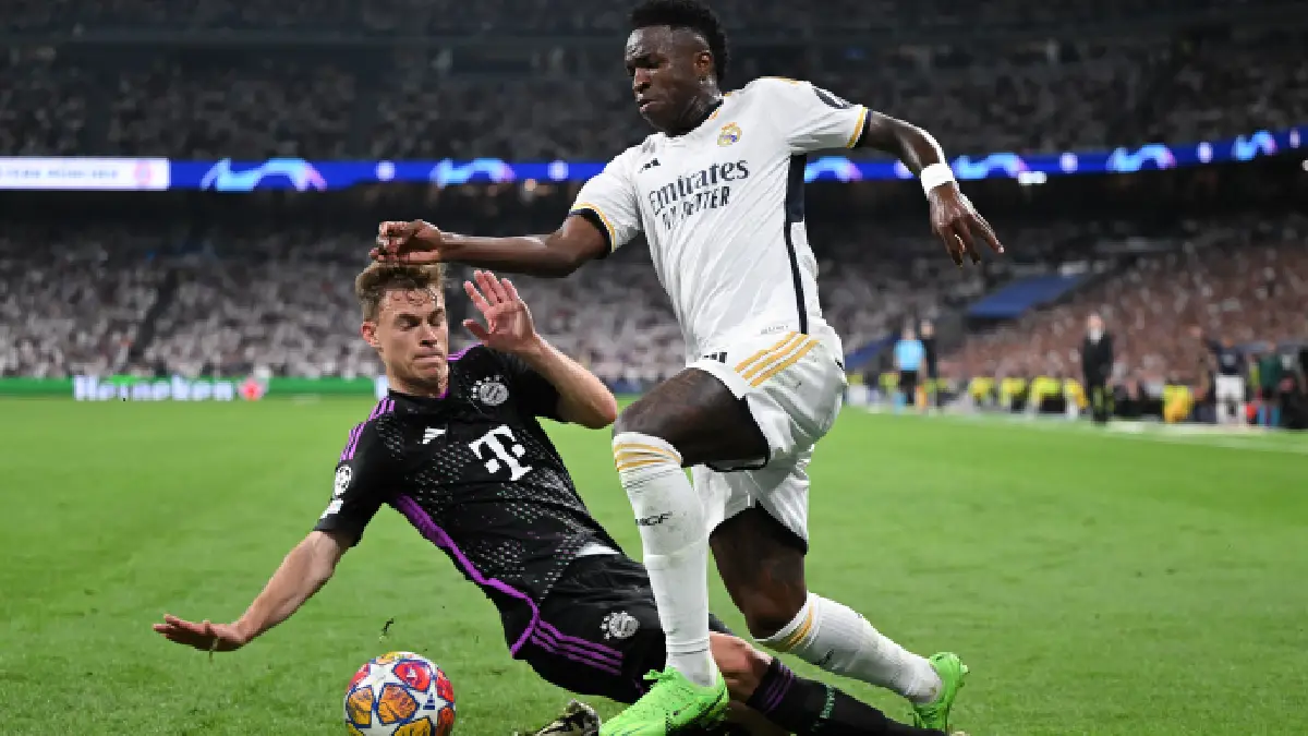 MADRID, SPAIN - MAY 08: Vinicius Jr. of Real Madrid CF competes for the ball with Joshua Kimmich of FC Bayern Munich during the UEFA Champions League semi-final second leg match between Real Madrid and FC Bayern München at Estadio Santiago Bernabeu on May 08, 2024 in Madrid, Spain. (Photo by David Ramos/Getty Images)
