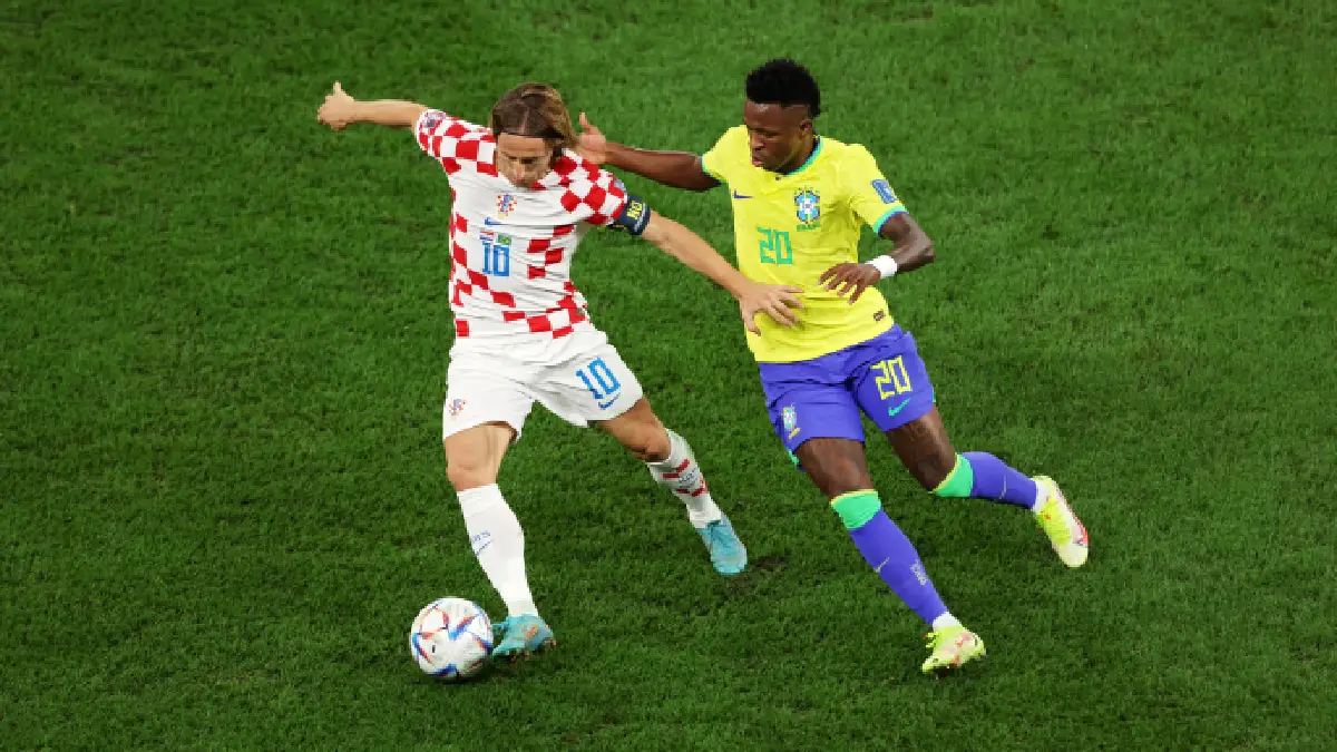 AL RAYYAN, QATAR - DECEMBER 09: Luka Modric of Croatia is challenged by Vinicius Junior of Brazil during the FIFA World Cup Qatar 2022 quarter final match between Croatia and Brazil at Education City Stadium on December 09, 2022 in Al Rayyan, Qatar. (Photo by Alex Pantling/Getty Images)