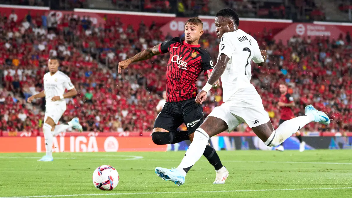 MALLORCA, SPAIN - AUGUST 18: Vinicius Junior of Real Madrid CF and Pablo Maffeo of RCD Mallorca compete for the ball during the La Liga match between RCD Mallorca and Real Madrid CF at Estadi de Son Moix on August 18, 2024 in Mallorca, Spain. (Photo by Alex Caparros/Getty Images)