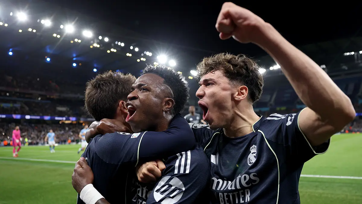 MANCHESTER, ENGLAND - MARCH 17: Vinicius Junior of Real Madrid celebrates scoring his team's first goal from the penalty spot with teammate Thiago Pitarch during the UEFA Champions League 2025/26 Round of 16 Second Leg match between Manchester City FC and Real Madrid CF at City of Manchester Stadium on March 17, 2026 in Manchester, England. (Photo by Carl Recine/Getty Images)