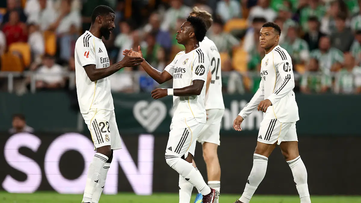SEVILLE, SPAIN - APRIL 24: Vinicius Junior of Real Madrid celebrates scoring his team's first goal with teammate Antonio Ruediger during the LaLiga EA Sports match between Real Betis Balompie and Real Madrid CF at Estadio La Cartuja on April 24, 2026 in Seville, Spain. (Photo by Fran Santiago/Getty Images)