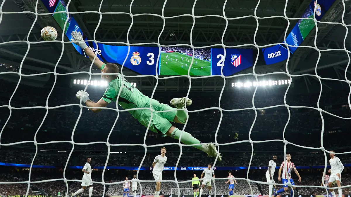 MADRID, SPAIN - MARCH 22: Andriy Lunin of Real Madrid dives for a save during the LaLiga EA Sports match between Real Madrid CF and Atletico de Madrid at Estadio Santiago Bernabeu on March 22, 2026 in Madrid, Spain. (Photo by Angel Martinez/Getty Images)