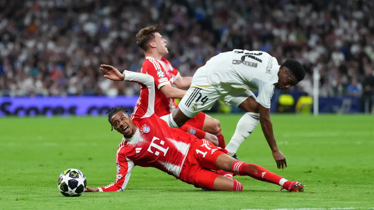MADRID, SPAIN - APRIL 07: Michael Olise of FC Bayern Munich is challenged by Aurelien Tchouameni of Real Madrid during the UEFA Champions League 2025/26 Quarter-Final First Leg match between Real Madrid CF and FC Bayern München at Estadio Santiago Bernabeu on April 07, 2026 in Madrid, Spain. (Photo by Angel Martinez/Getty Images)