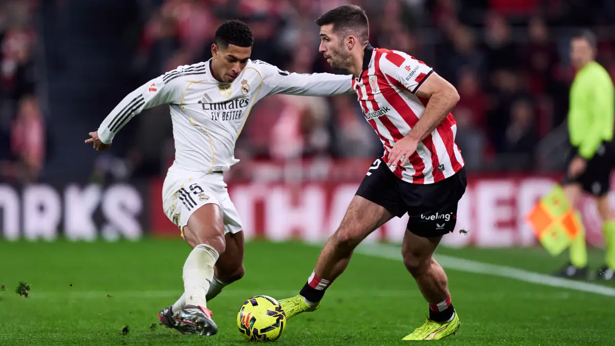 BILBAO, SPAIN - DECEMBER 03: Jude Bellingham of Real Madrid is challenged by Jesus Areso of Athletic Club during the LaLiga EA Sports match between Athletic Club and Real Madrid CF at Estadio de San Mames on December 03, 2025 in Bilbao, Spain. (Photo by Juan Manuel Serrano Arce/Getty Images)