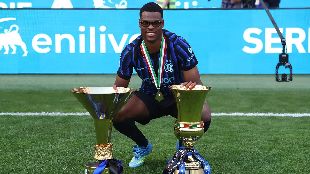 MILAN, ITALY - MAY 17: Denzel Dumfries of FC Internazionale Milano poses for a photo with the Coppa Campioni d'Italia and Coppa Italia trophies following the Serie A match between FC Internazionale and Hellas Verona FC at Giuseppe Meazza Stadium on May 17, 2026 in Milan, Italy. (Photo by Marco Luzzani/Getty Images)